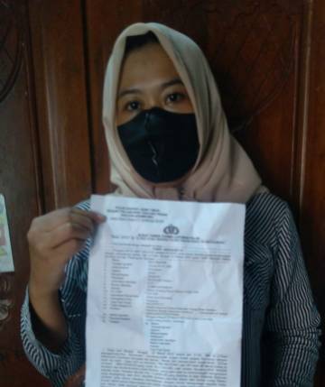 Korban menunjukkan bukti laporan Polisi