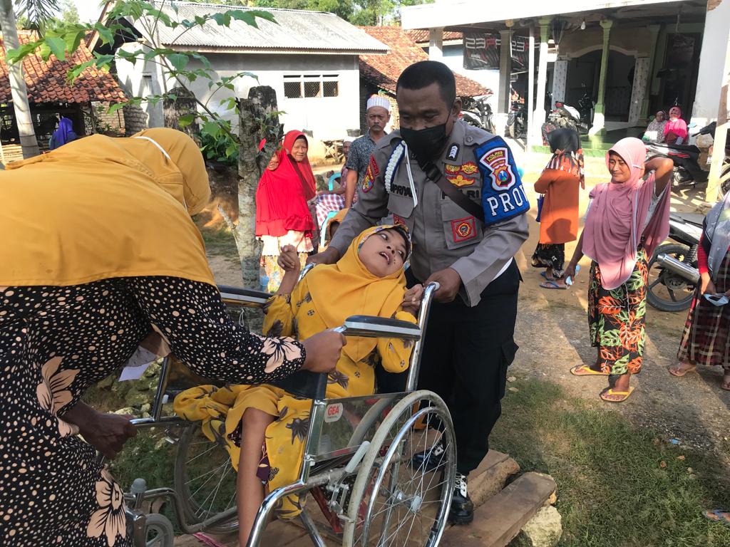 Bripka Supriadi saat bantu warga yang cacat