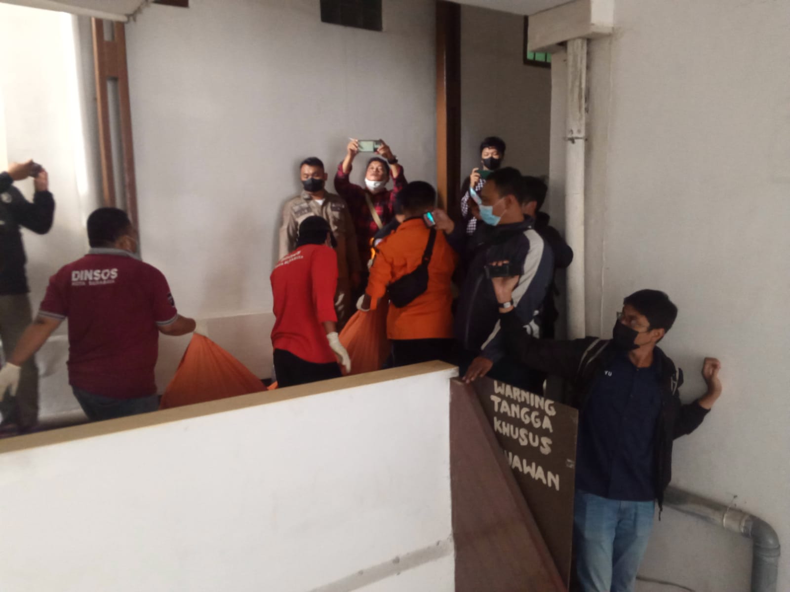 Petugas saat evakuasi korban dari dalam kamar hotel