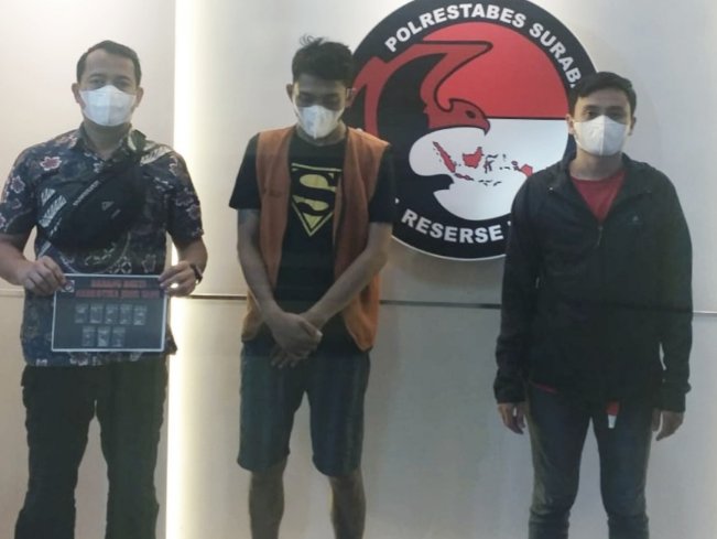 Pelaku tengah diapit petugas Polisi Tanjung Perak