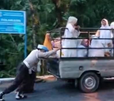 Petugas Kepolisian saat membantu mobil hendak pengajian yang mogok