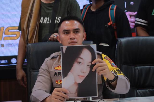 Polisi menunjukan foto korban pembunuhan