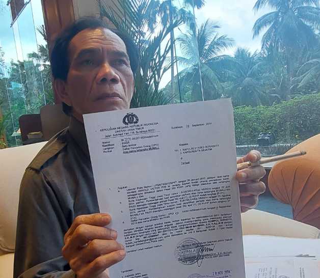 Pelapor menunjukkan surat pemberitahuan P21 kasus pemalsuan petok D