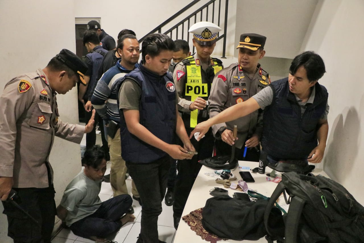 Petugas gabungan memeriksa pemotor yang terjaring razia di batas kota