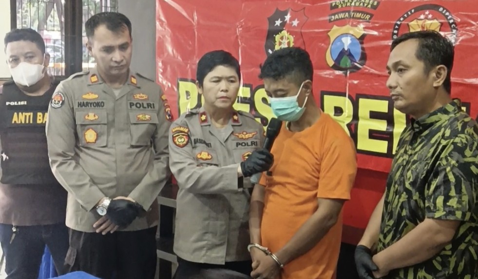 Pelaku tengah diapit Kapolsek Tenggilis dan anggota